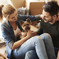 A couple moving into their new apartment with a puppy.